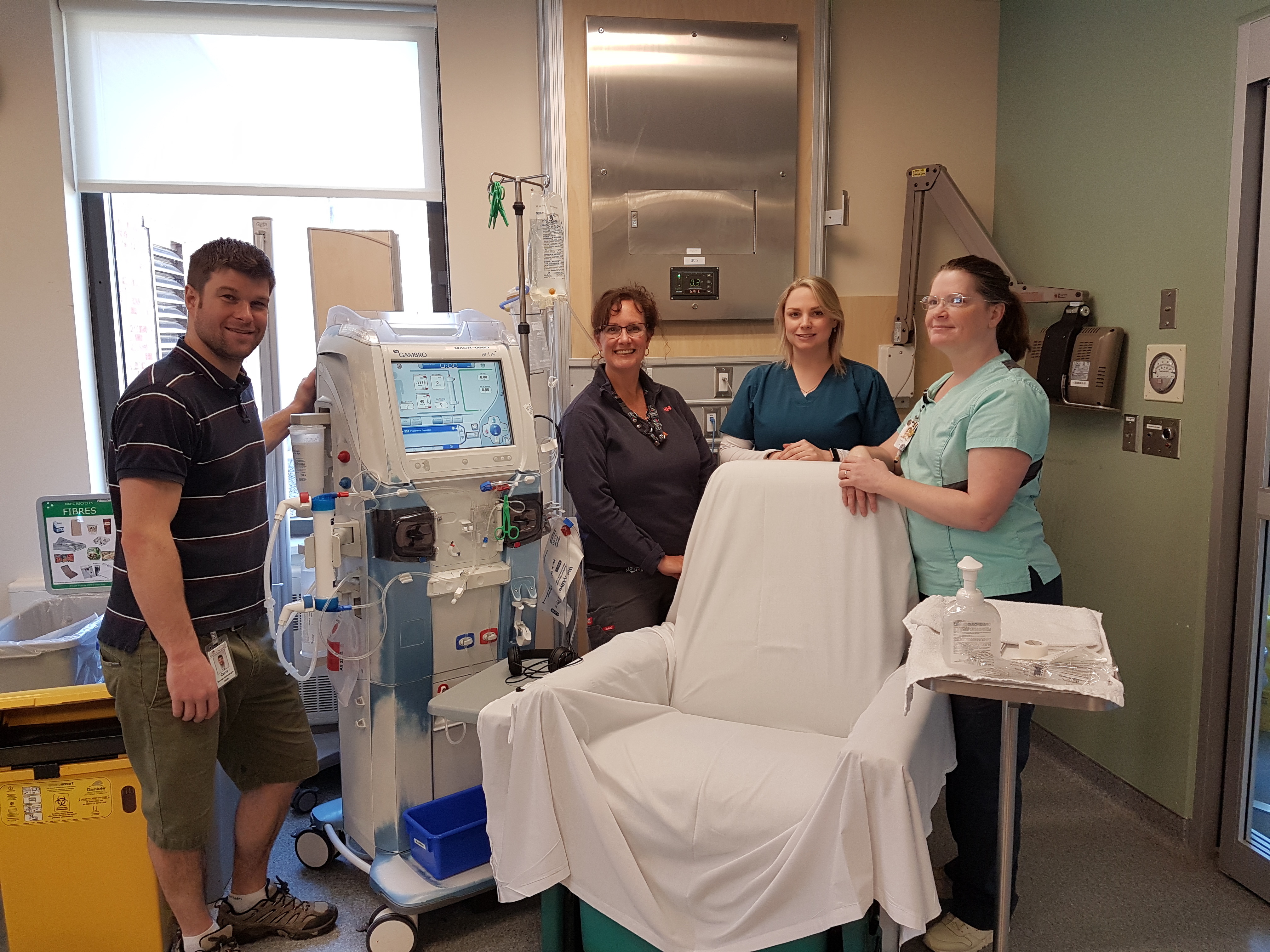 Dialysis team members with hemodialysis machine and patient chair